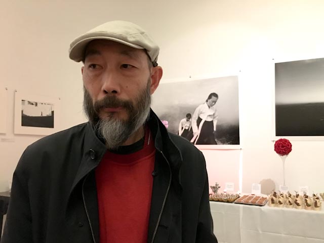 Le photographe chinois Mo Yi, devant des œuvres de Lee Gap Chul